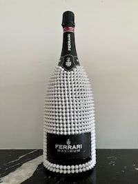 a bottle of ferrari champagne made out of pearls