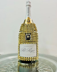 a bottle of champagne with gold spikes on it