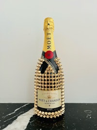 a bottle of champagne with gold spikes on it