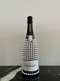 a bottle of ferrari champagne with pearls on it