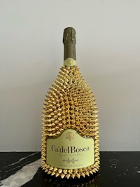 a bottle of champagne with gold spikes on it