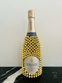 a bottle of champagne with gold spikes on it