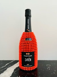 a bottle of champagne with orange spikes on it