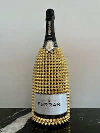 a bottle of ferrari champagne with gold spikes on it